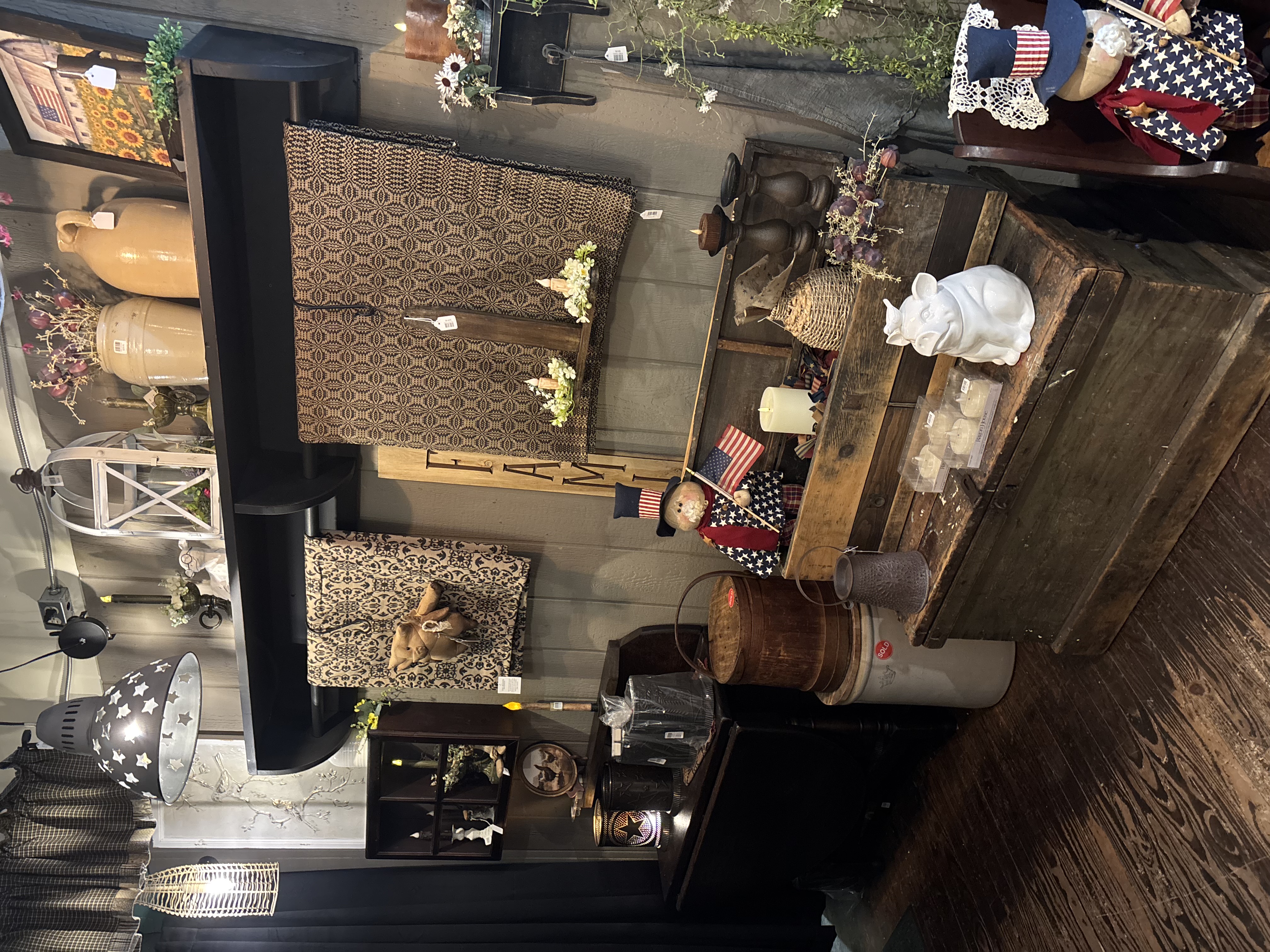 Shop display with coverlets and stoneware crocks
